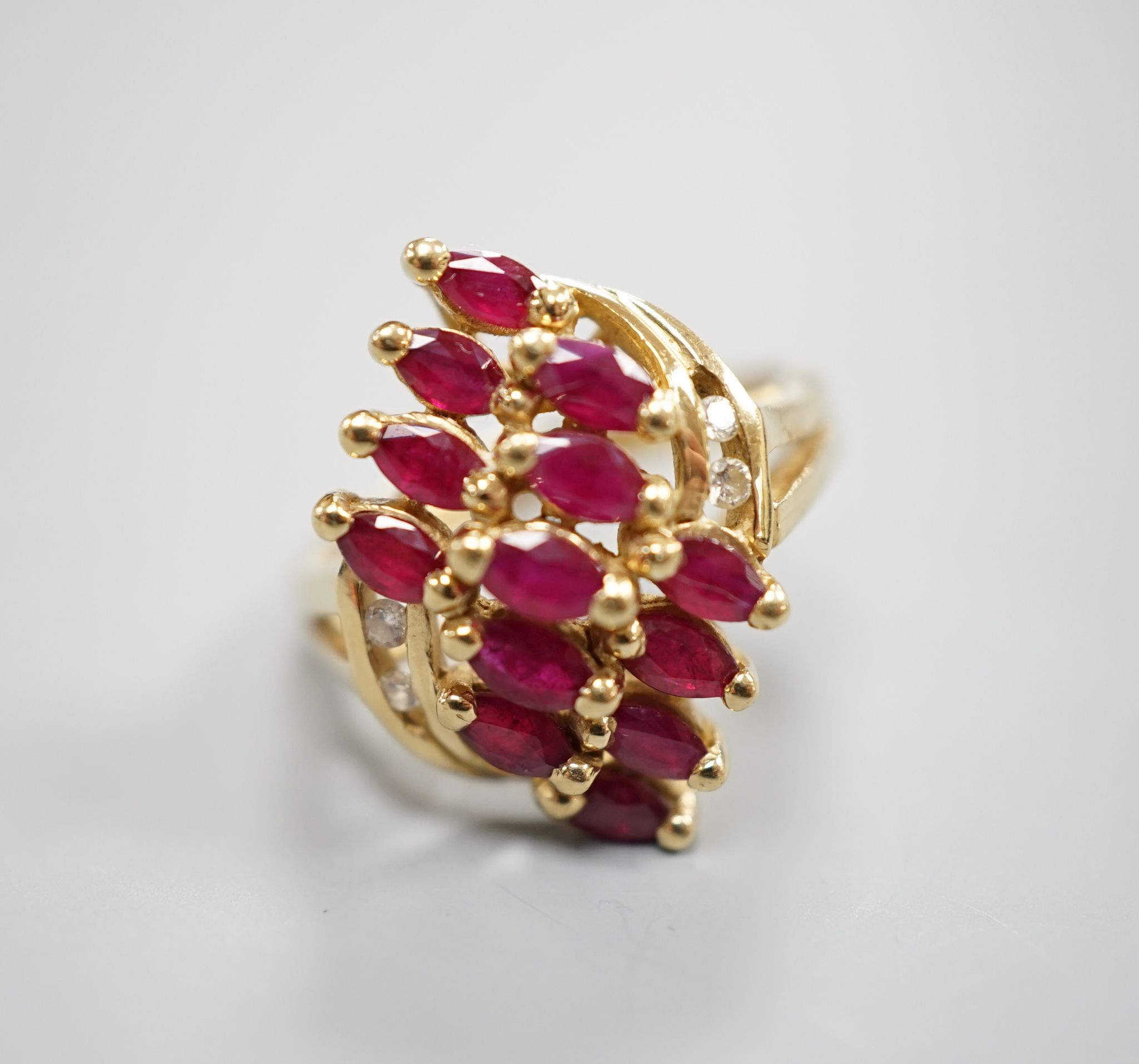 A modern 14k yellow metal ,ruby and diamond cluster set dress ring, size M, gross weight 5 grams.